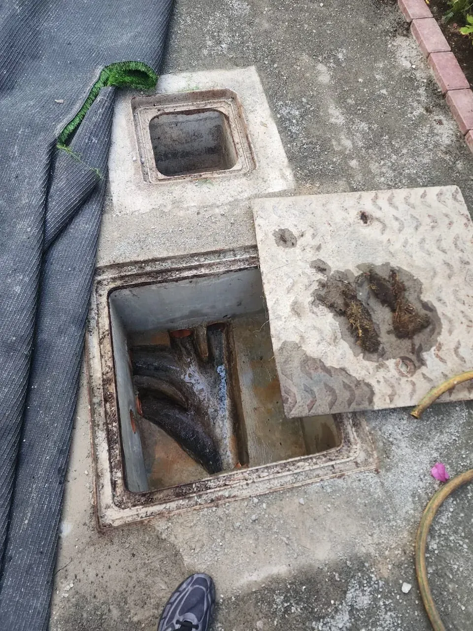 Outdoor inspection chamber opened for drainage cleaning and blockage removal Outdoor inspection chamber opened for drainage cleaning and blockage removal