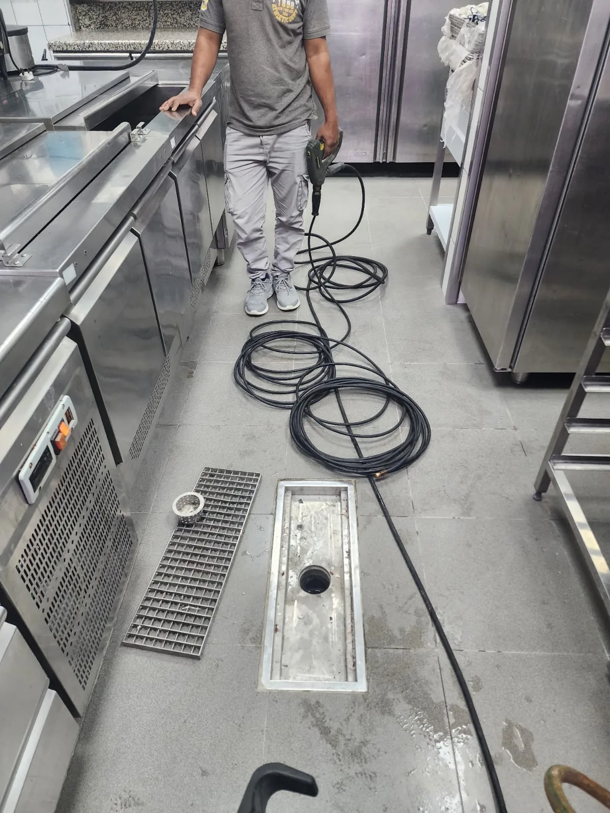 Commercial kitchen drain cleaning work with cable equipment and floor drain access Commercial kitchen drain cleaning work with cable equipment and floor drain access
