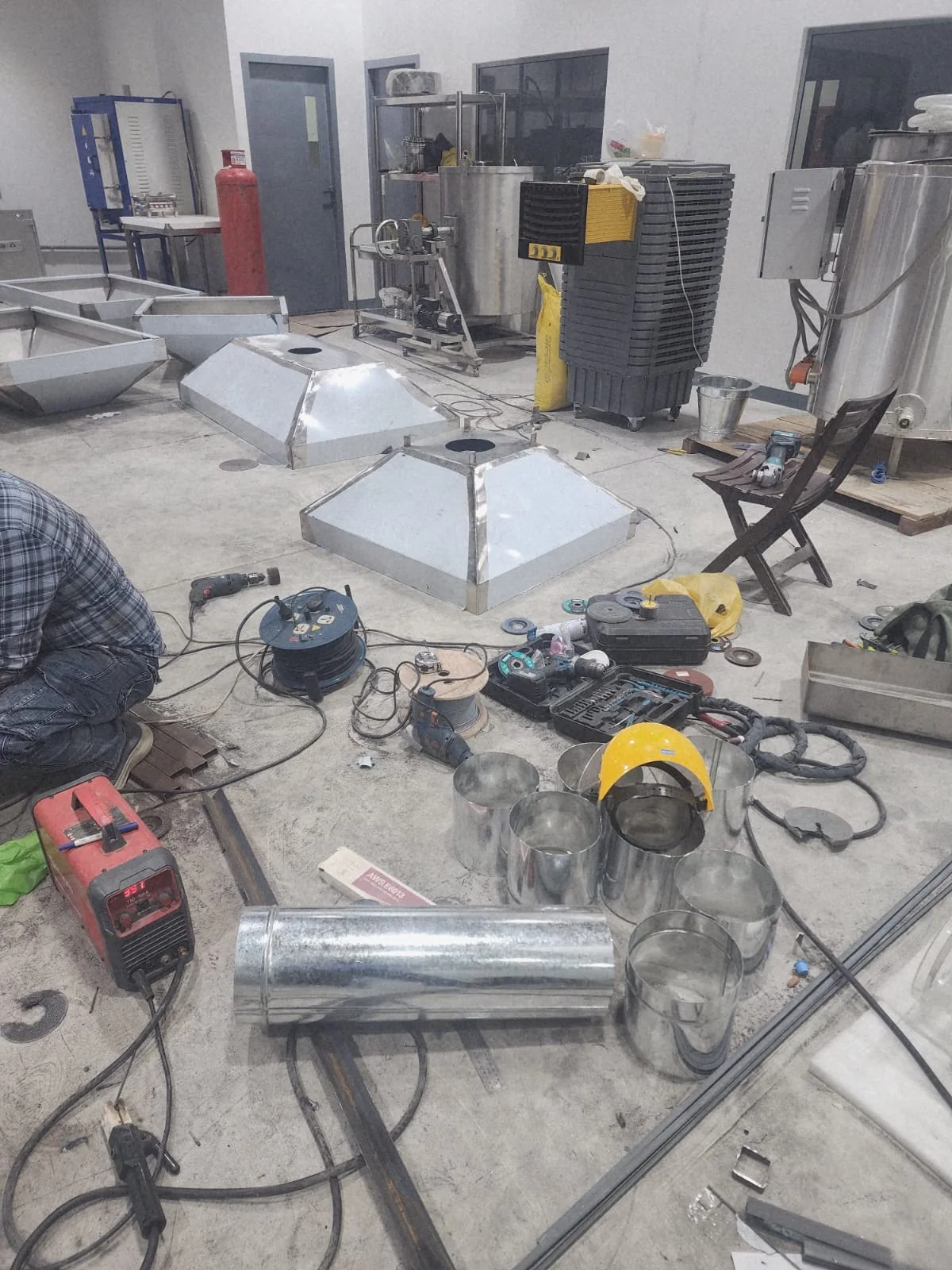 Hood and duct components with fabrication tools in the workshop