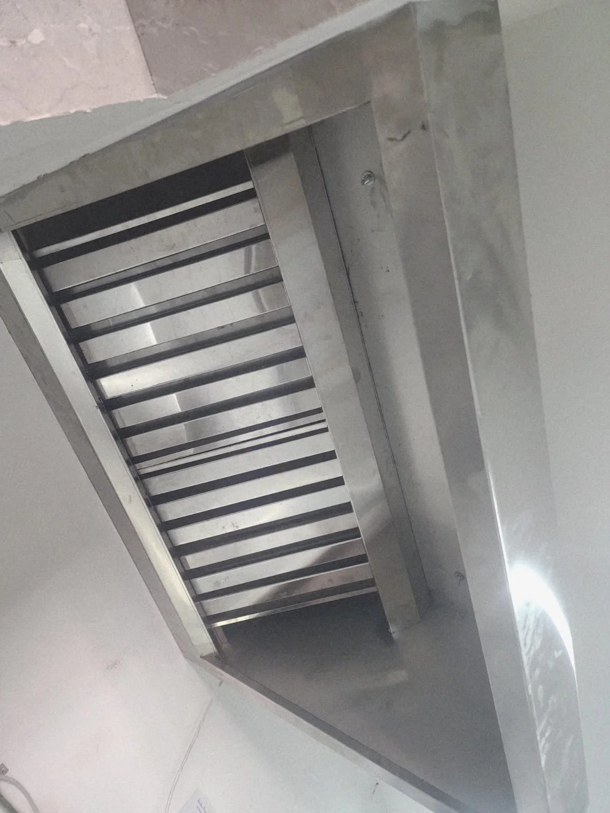 Installed commercial kitchen hood with stainless baffle-filter detail