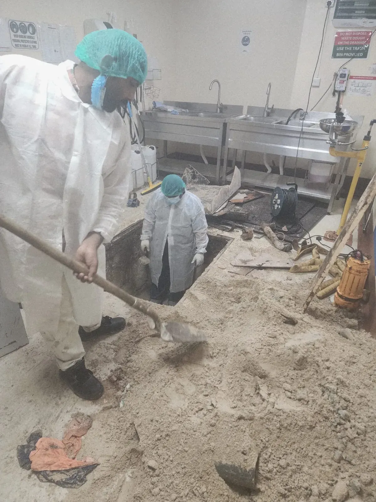 BMS technicians preparing the commercial bakery floor area for grease trap installation in DIP